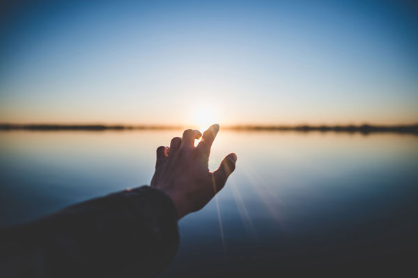 Grief Recovery - Hand pointing at the sun.